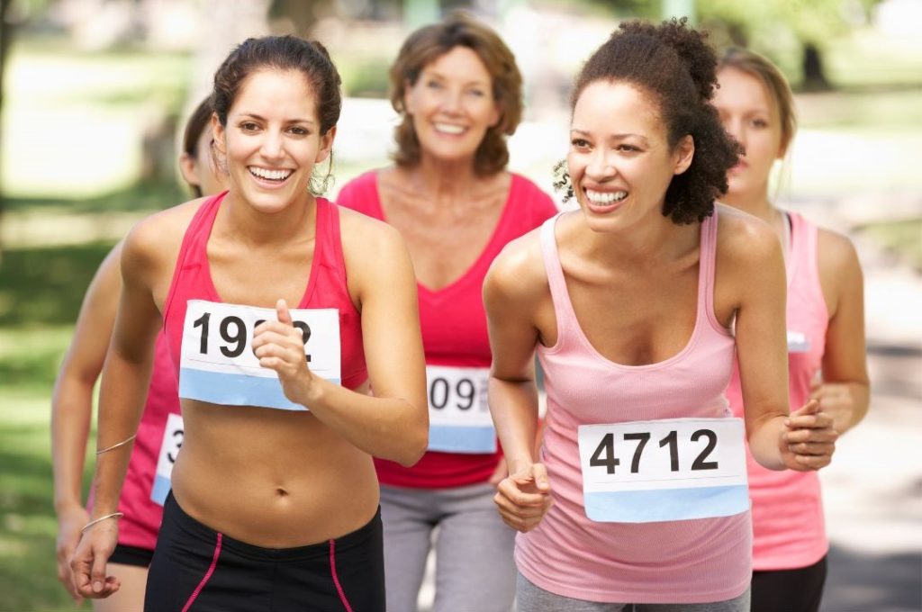 fünf Frauen joggen und lachen