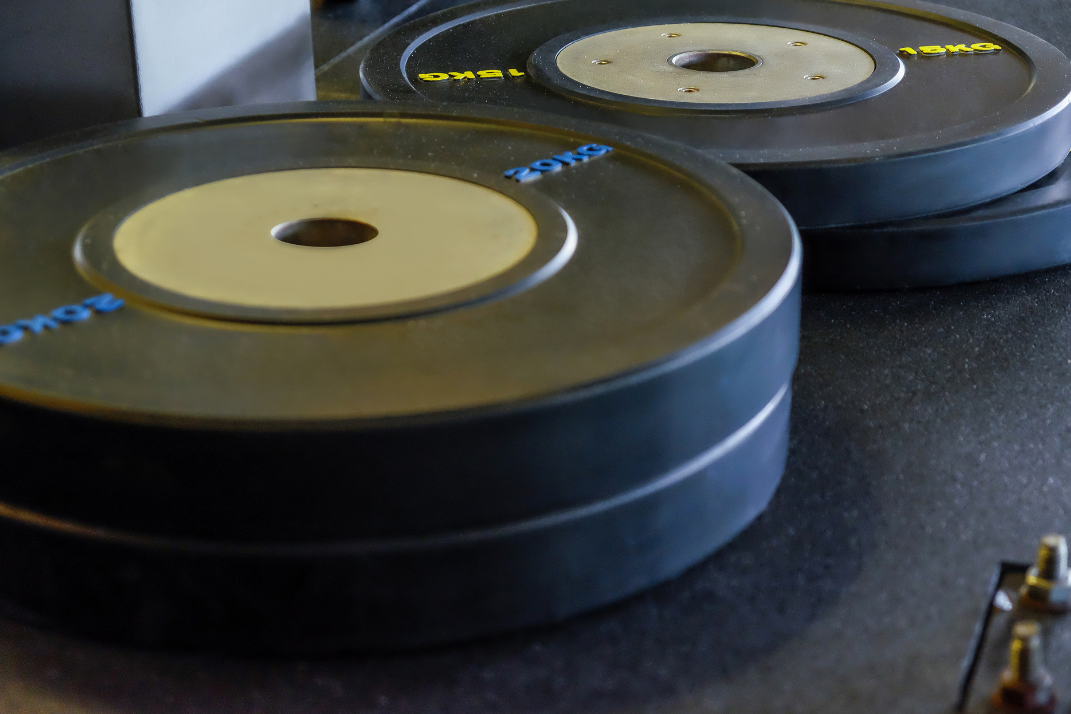 Bumper Plates liegen am Boden im Gym