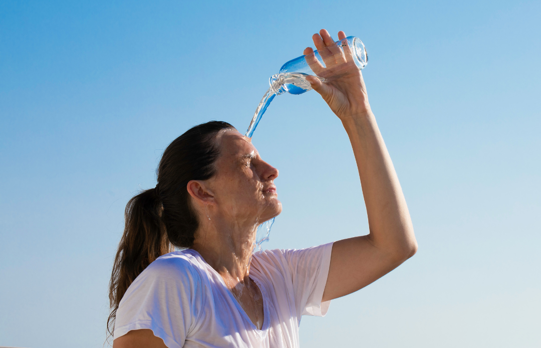 sportliche Frau in Sonne schwitzt und trinkt Wasser
