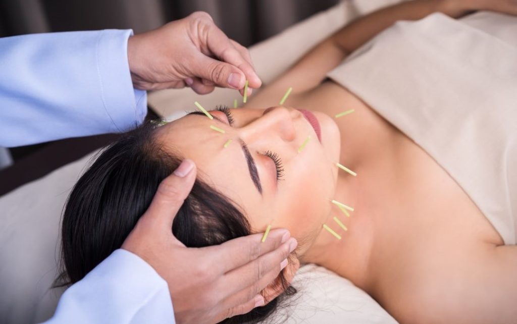 Frau kriegt Akupunktur im Gesicht