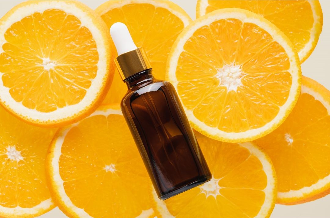 Vitamin C Serum vor Orangenscheiben