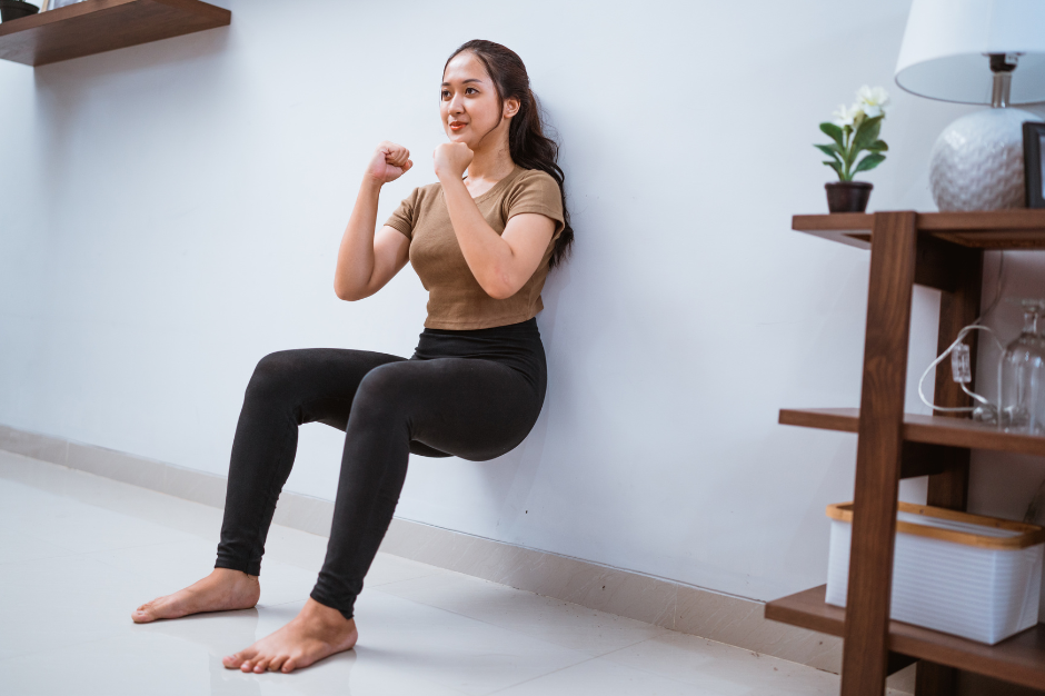 Kann man mit Wand-Pilates abnehmen, Frau macht Kniebeugen an Wand