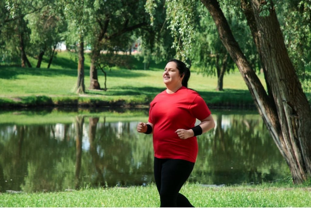 Der beste Weg zum Abnehmen durch joggende übergewichtige Frau im Wald dargestellt