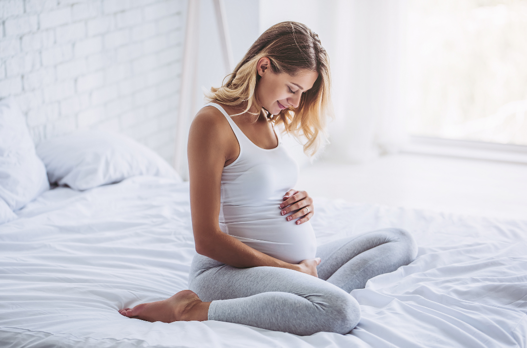 schwangere Frau im Bett symbolisiert Ozempic-Babies
