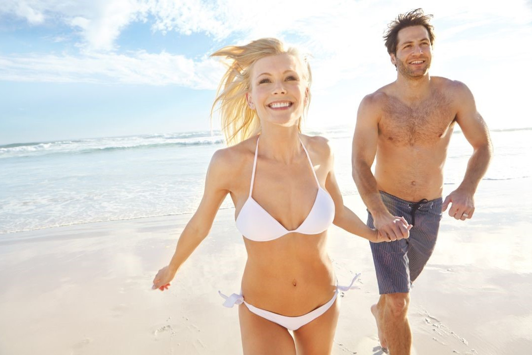 sportliches Paar am Strand symbolisiert Bikini-Workout