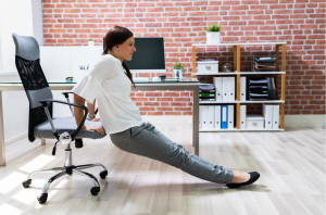Frau macht im Büro Trizeps Dips auf Stuhl gegen Winkearme
