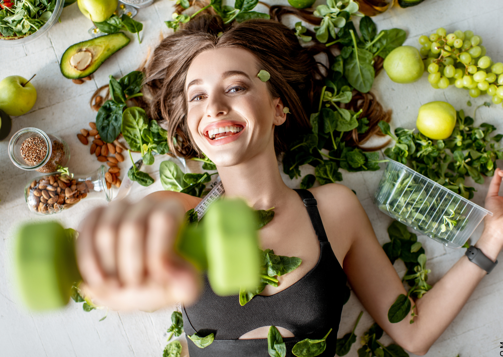 Gewicht halten, symbolisiert von fitter Frau mit Kurzhantel und Salat um sie herum