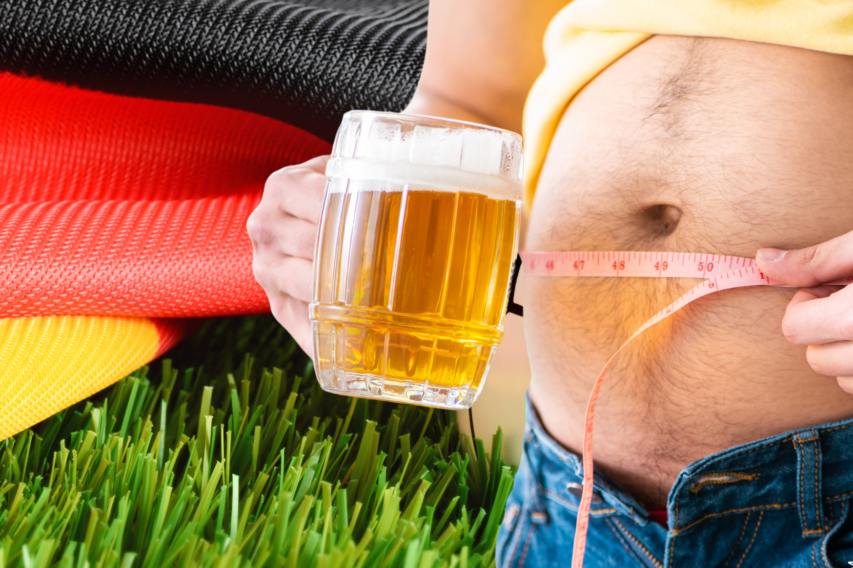 Mann mit Bierbauch und Bier vor Deutschland Fahne