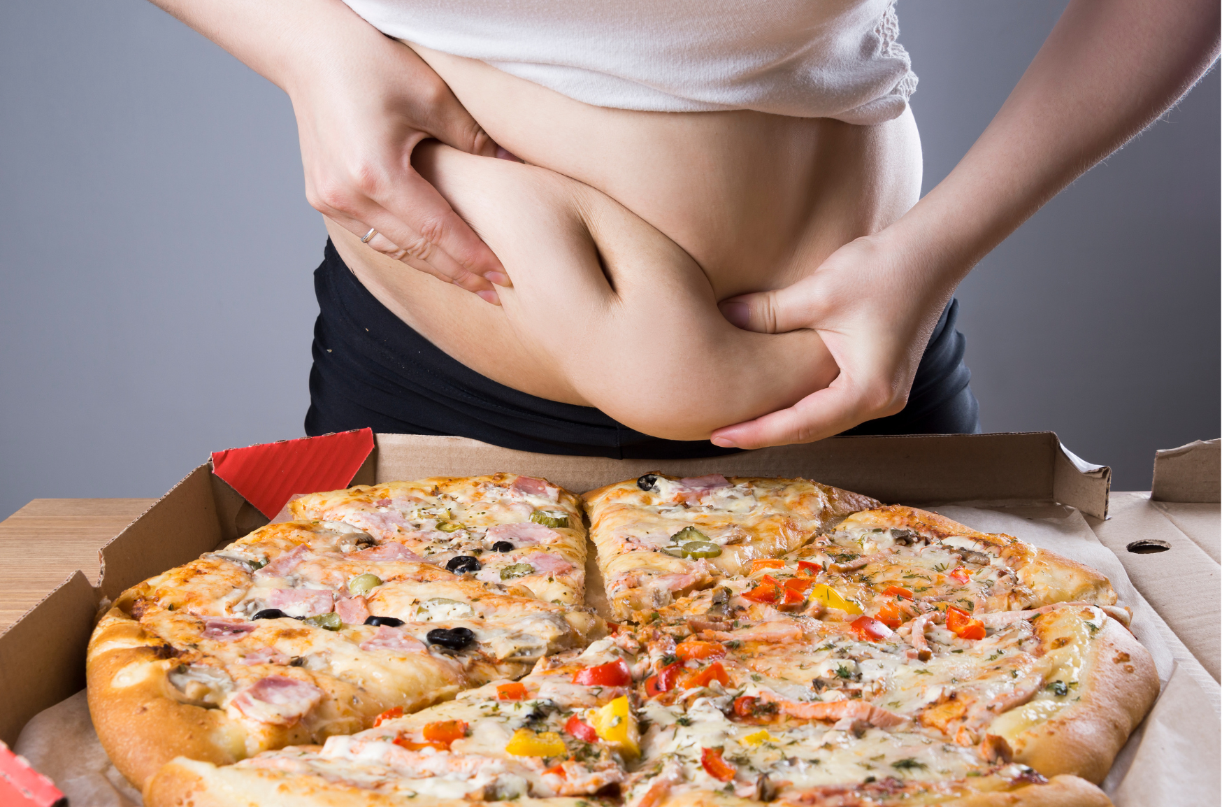 Fettverbrennung dargestellt von übergewichtigem Frauenbauch mit Pizza