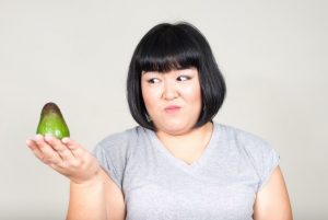 Abnehmen mit Avocado - dicke Frau schaut skeptisch