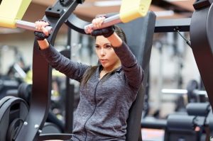 Krafttraining unterstützt beim Abnehmen mit Hashimoto dargestellt von Frau im Gym