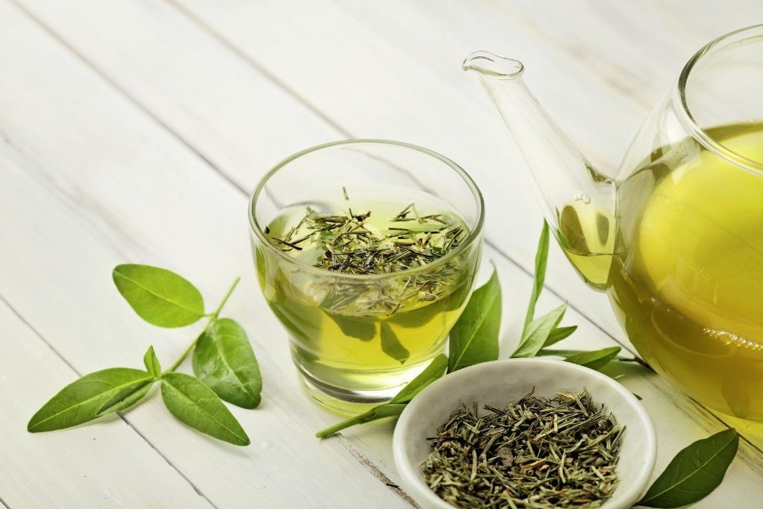 Tee zum Abnehmen dargestellt von Kanne, Tasse und Teeblätter