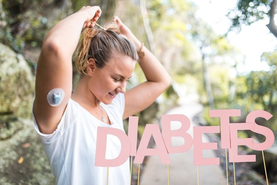 Bewegung und Diabetes dargestellt von junger Joggerin und Schrift